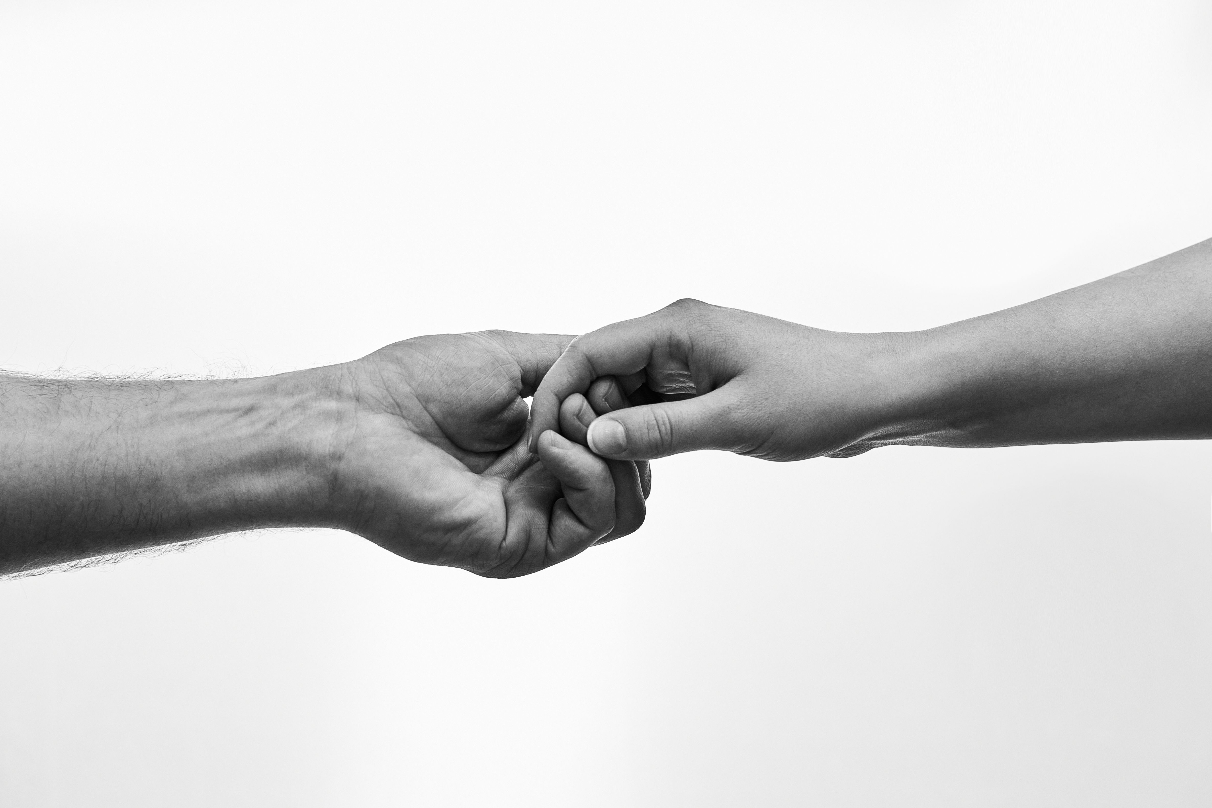Two hands gently holding one another